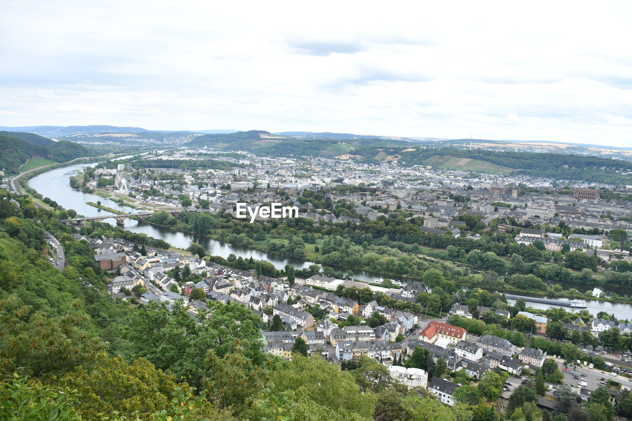 HIGH ANGLE VIEW OF TOWNSCAPE AND TREES AGAINST SKY