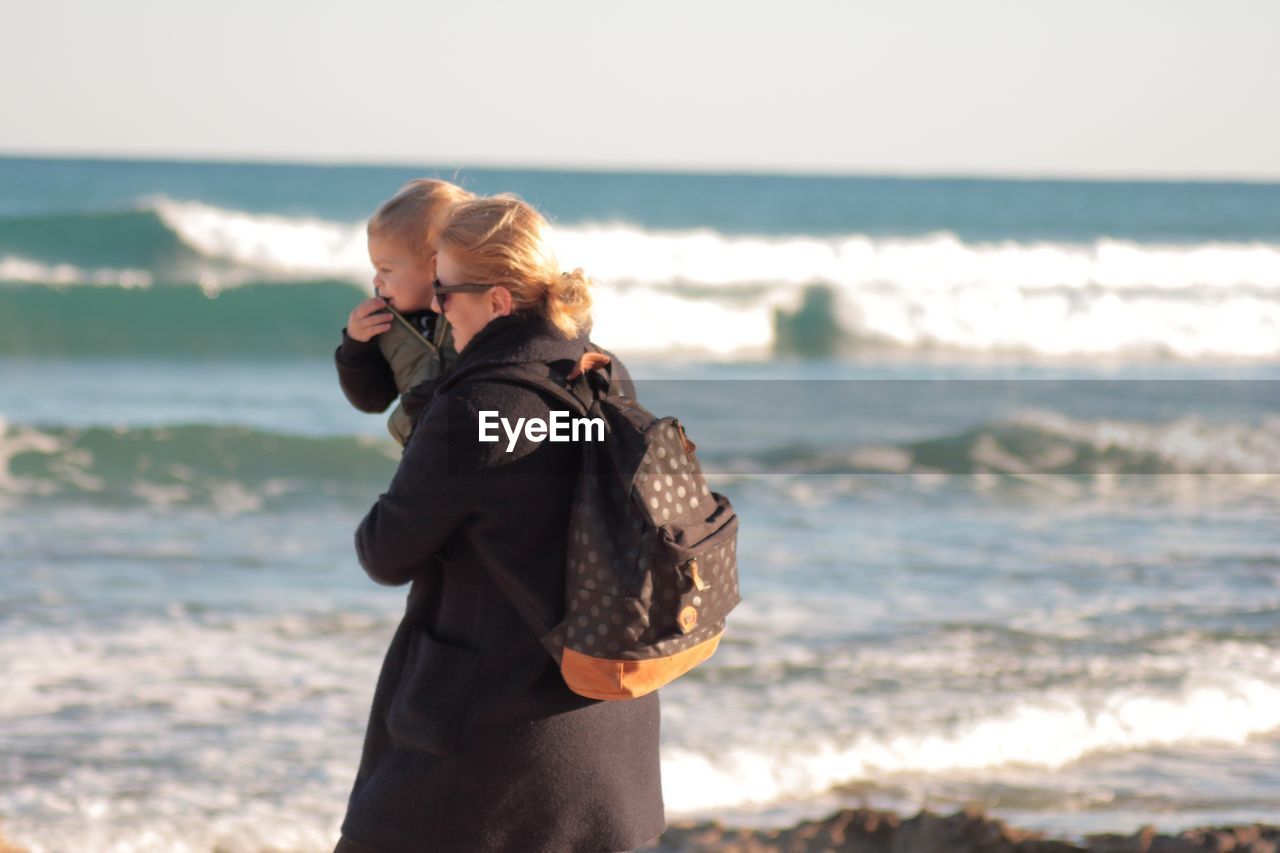 Woman standing on beach against sea