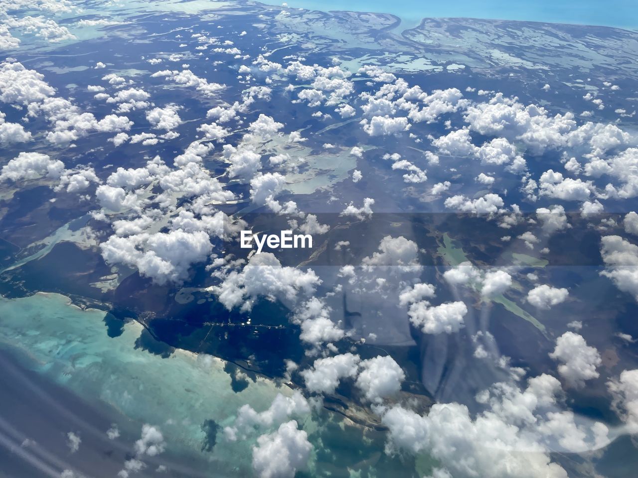aerial view, environment, aerial photography, landscape, cloud, scenics - nature, nature, sky, beauty in nature, mountain range, airplane, air vehicle, snow, travel, no people, cold temperature, day, winter, transportation, outdoors, flying, blue, land, water, tranquil scene, tranquility, idyllic, high angle view, horizon, white, mode of transportation, aircraft wing, earth, non-urban scene, sea, ice, ice cap, travel destinations