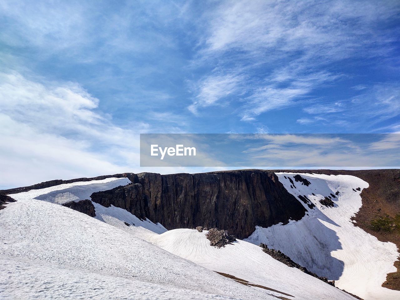 Scenic view of snowcapped volcanic rock mountains against sky 