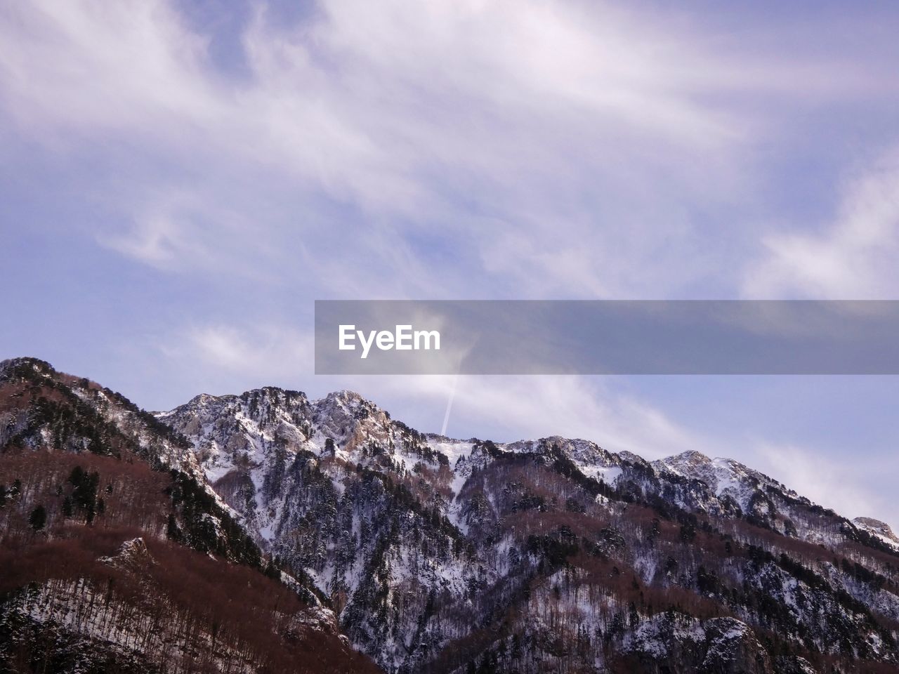 Low angle view of snowcapped mountains against sky