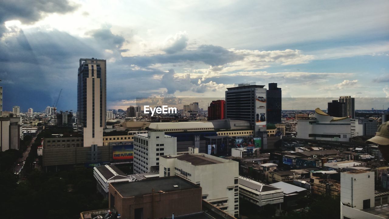 View of cityscape against cloudy sky