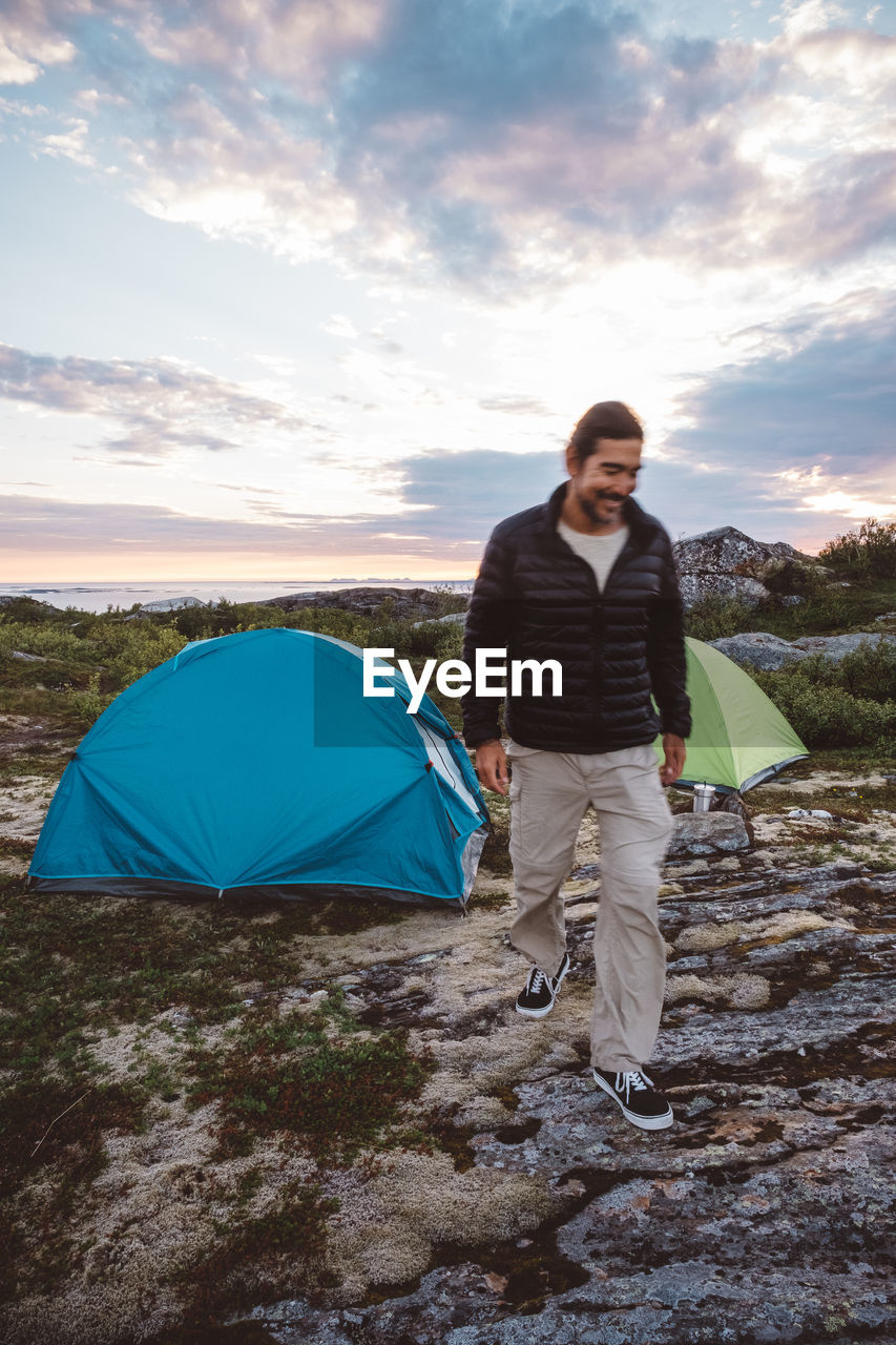 Man walking in a campsite smiling