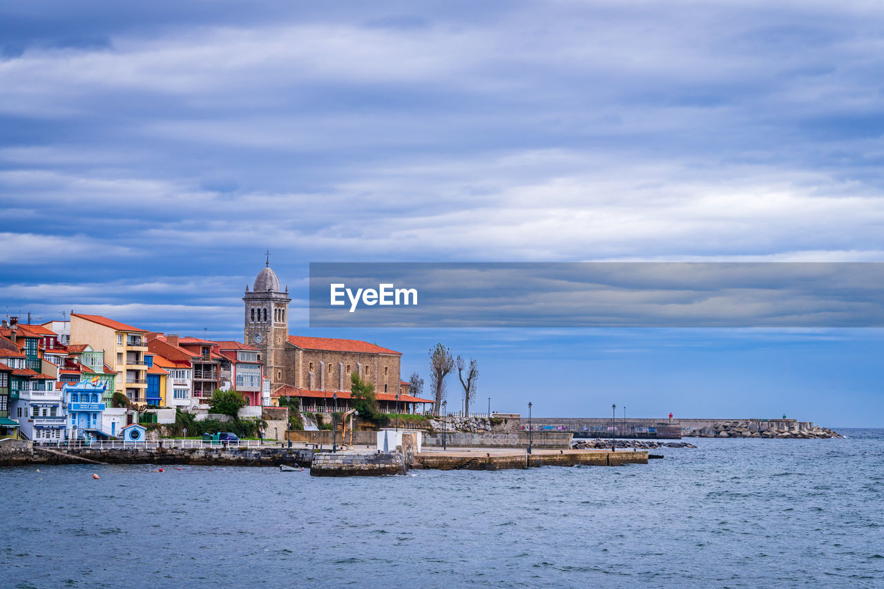 buildings by sea against sky