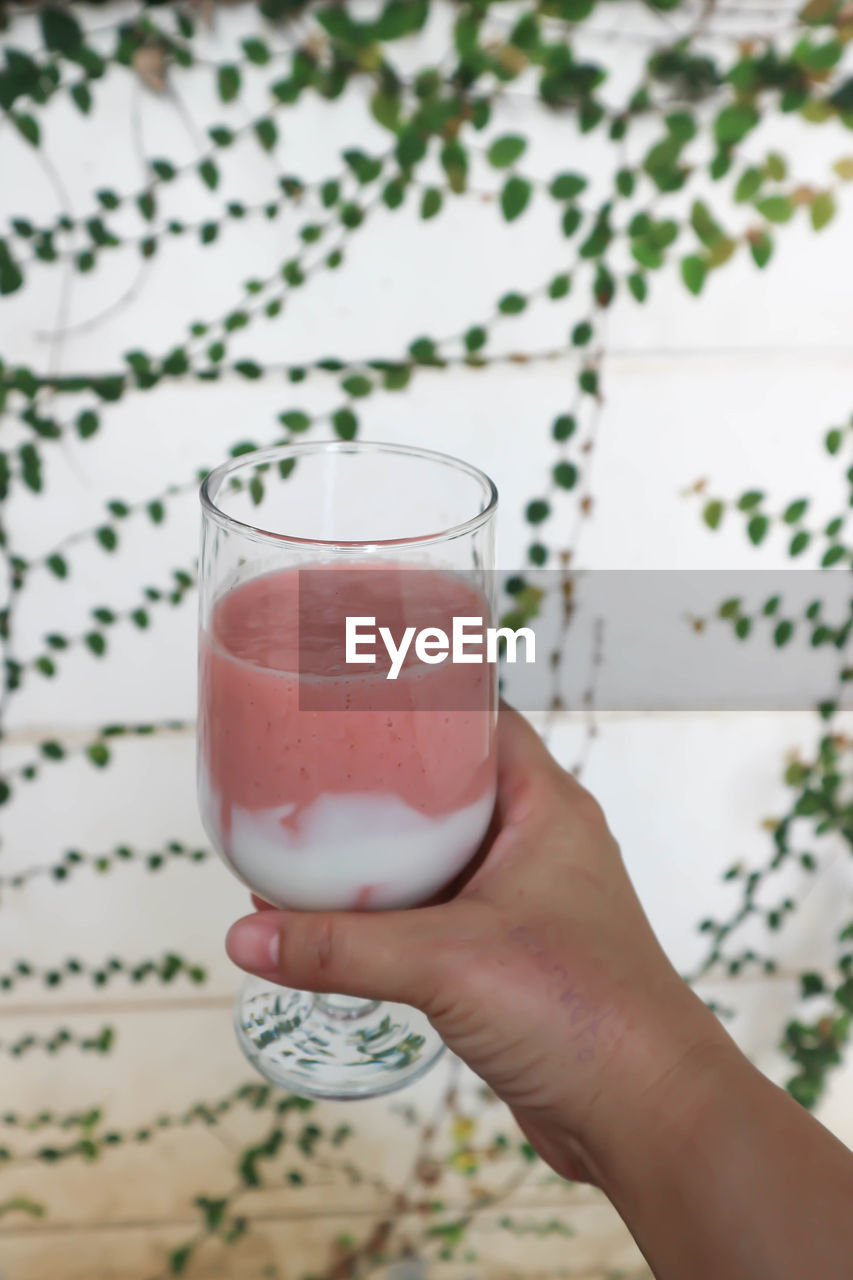 CLOSE-UP OF HAND HOLDING DRINK WITH GLASS