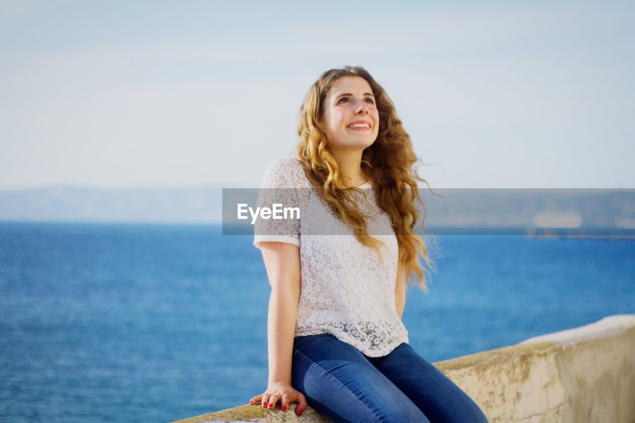 PORTRAIT OF YOUNG WOMAN STANDING IN WATER