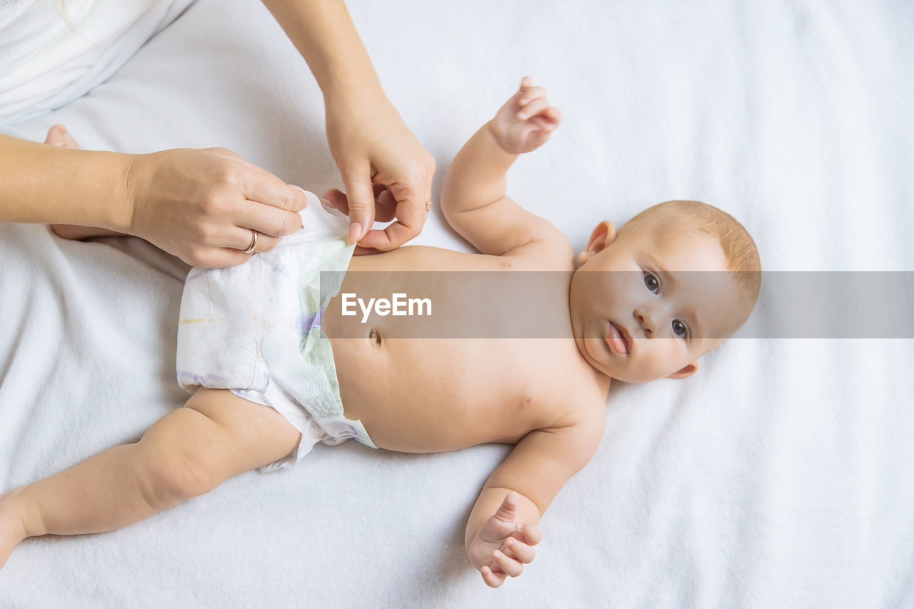 High angle view of baby girl lying on bed at home