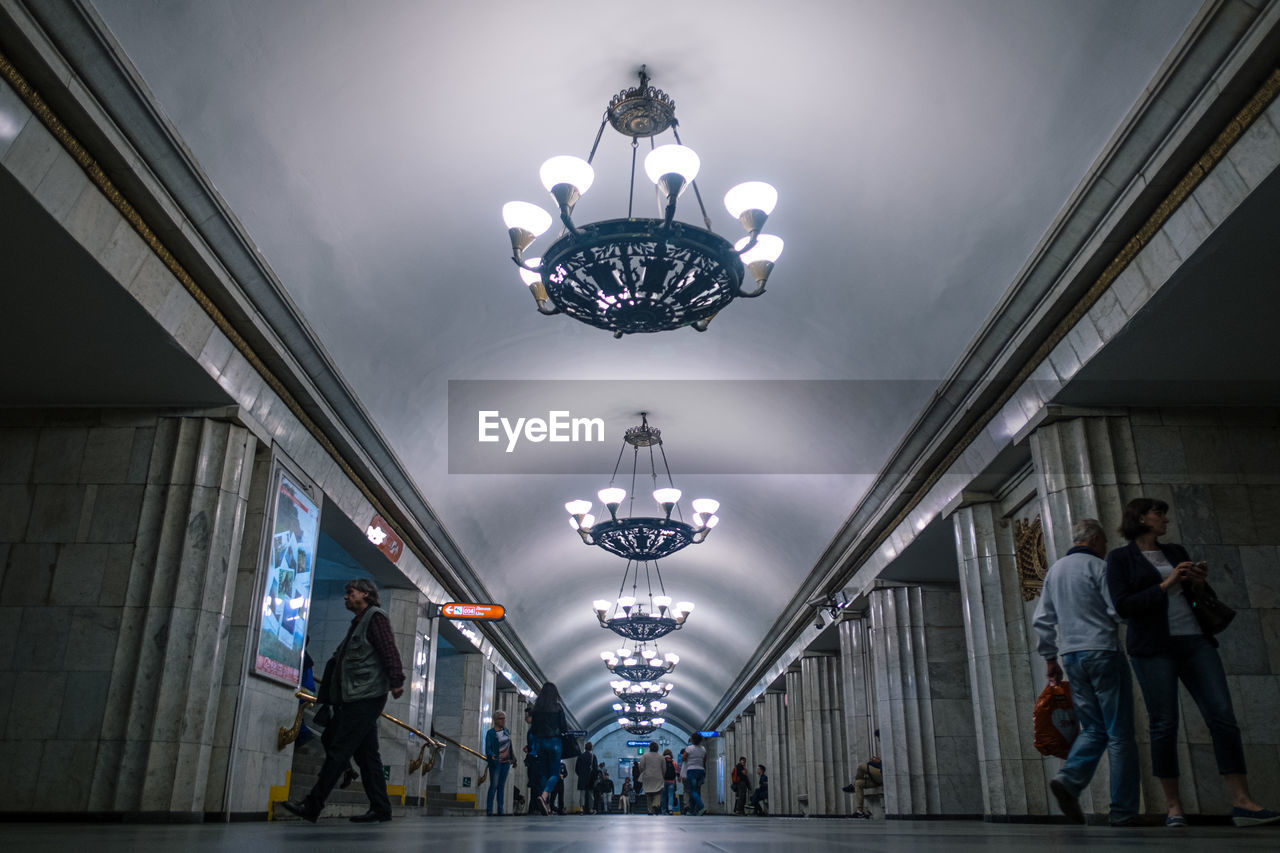 PEOPLE WALKING ON ILLUMINATED CEILING OF LIGHTS