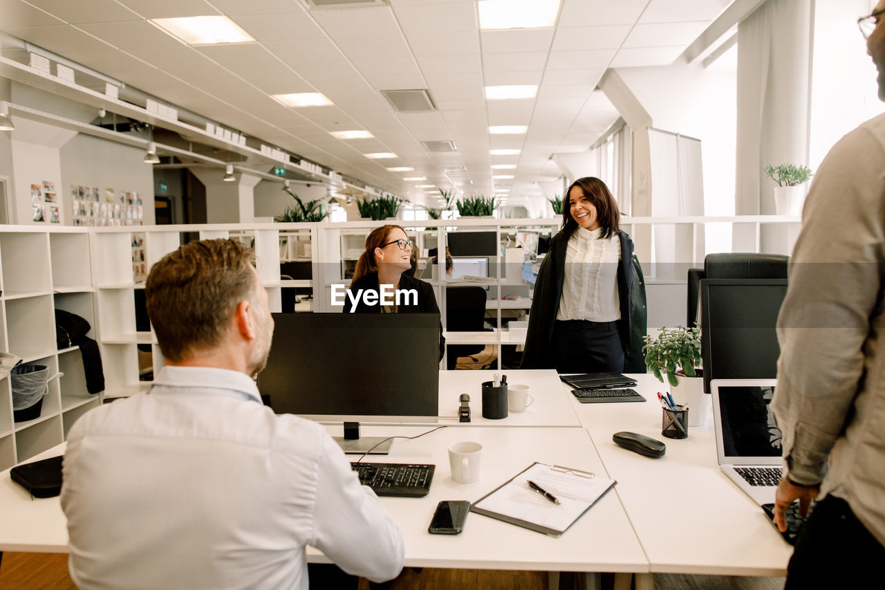 Smiling colleagues working at desk in office