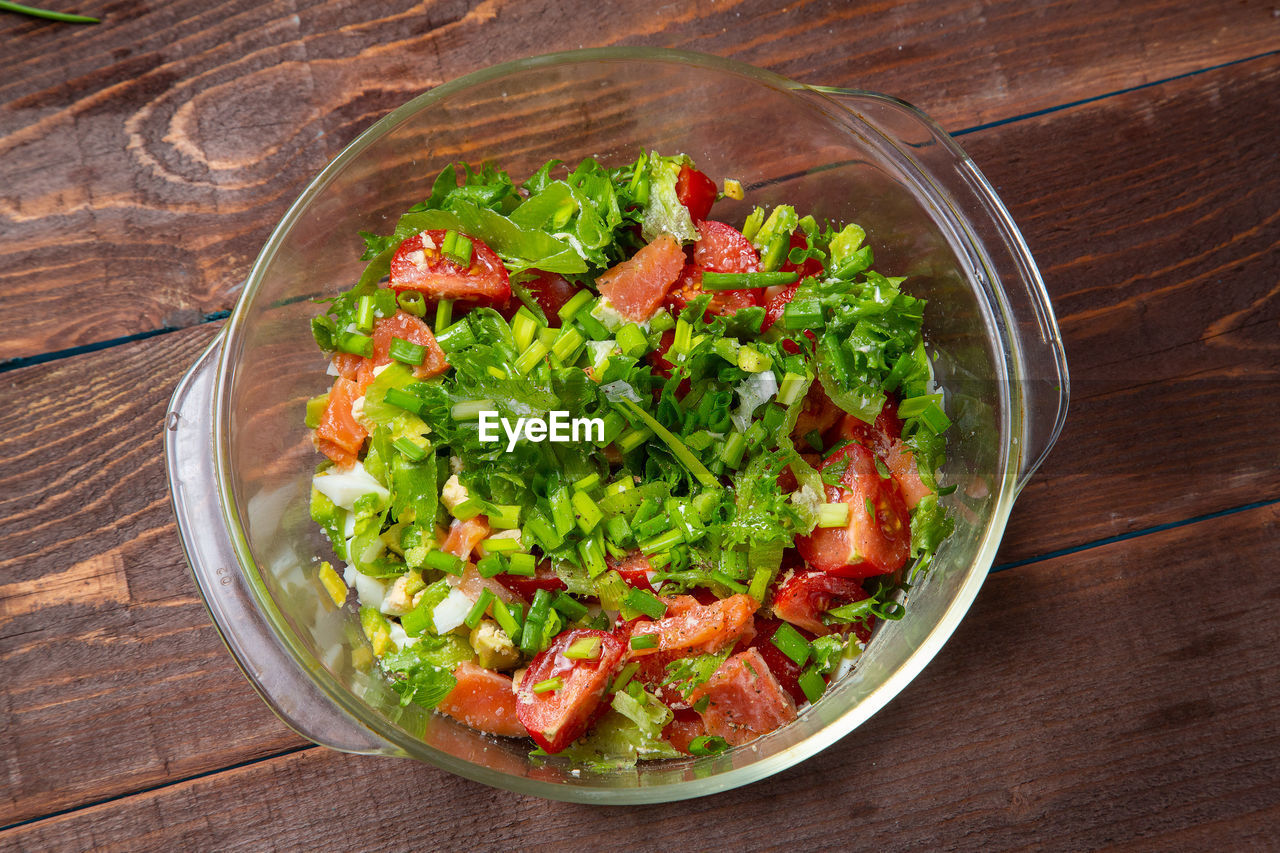 food and drink, food, healthy eating, vegetable, wellbeing, salad, freshness, wood, dish, lettuce, bowl, produce, fruit, no people, high angle view, indoors, table, vegetarian food, green, tomato, meal, studio shot, herb, cuisine, organic, salad bowl, crockery, spice, arugula, garnish, plant