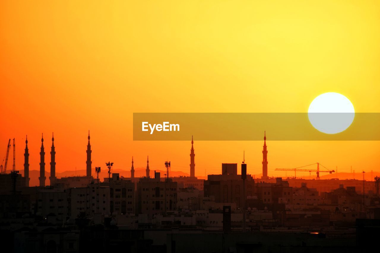 Silhouette buildings against sky during sunset