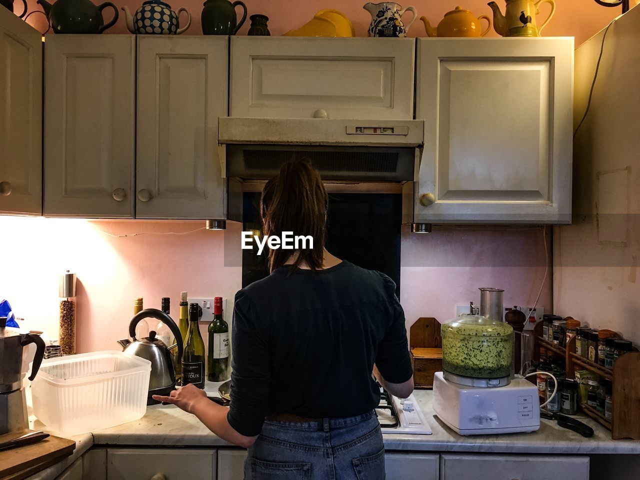 Rear view of woman cooking in kitchen at home