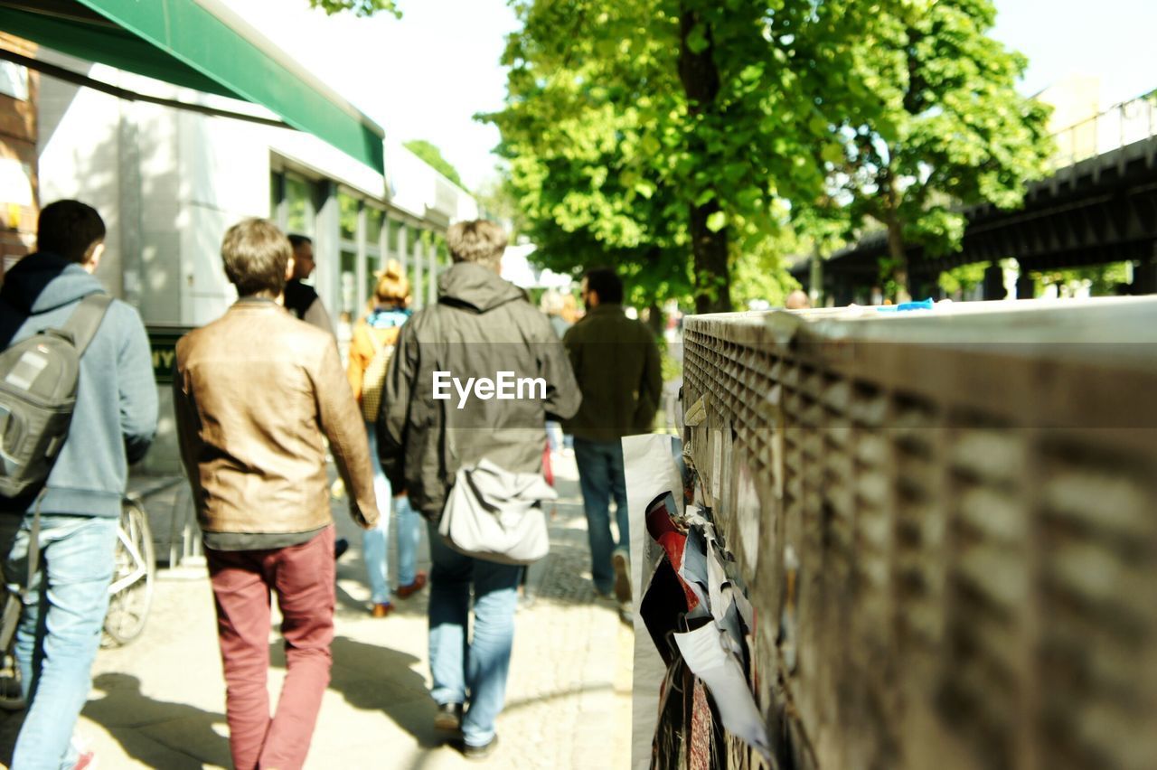 Rear view of people walking on footpath