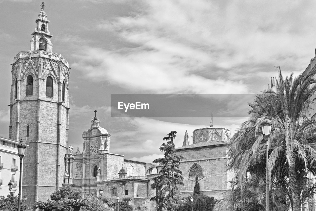 Low angle view of valencia cathedral against cloudy sky