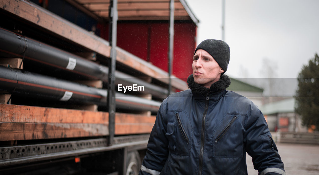 Working man looking away while standing outdoors