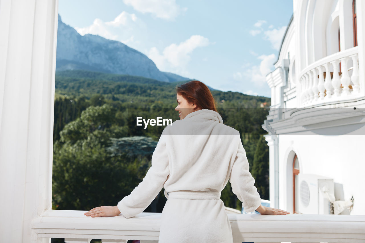 Rear view of woman looking through window