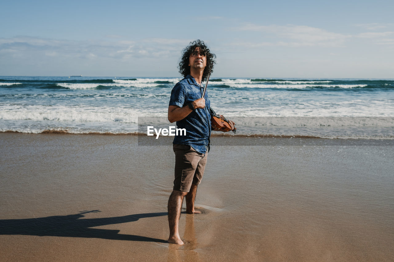 Man playing violin at beach