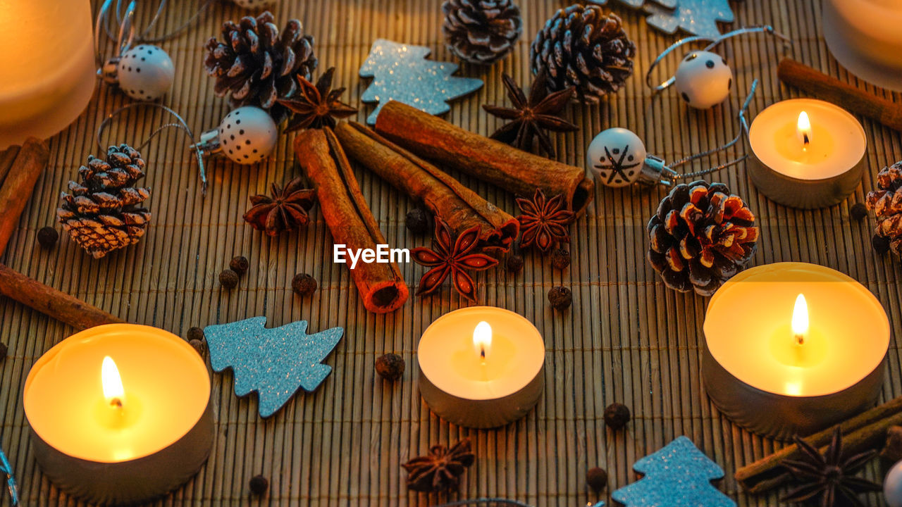 Close-up of burning tea lights decorations and spices on table