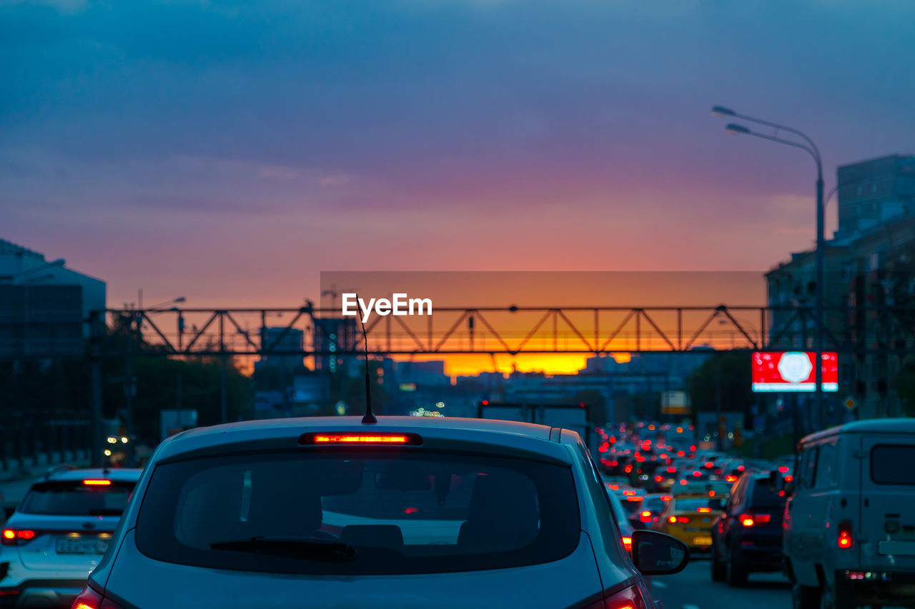 Traffic jam on the road in the evening at sunset in summer. red lights from headlights.