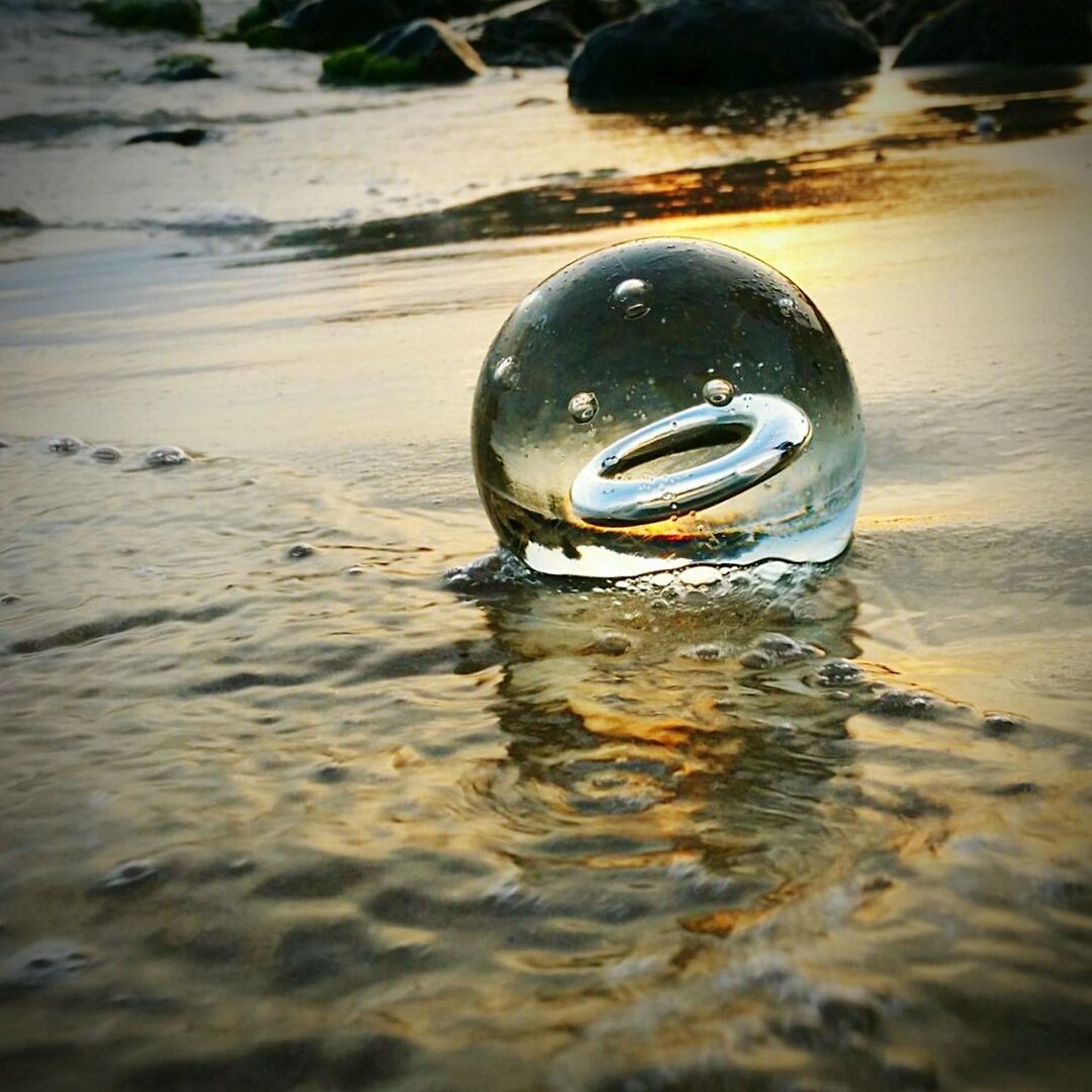 Crystal ball on shore during sunset