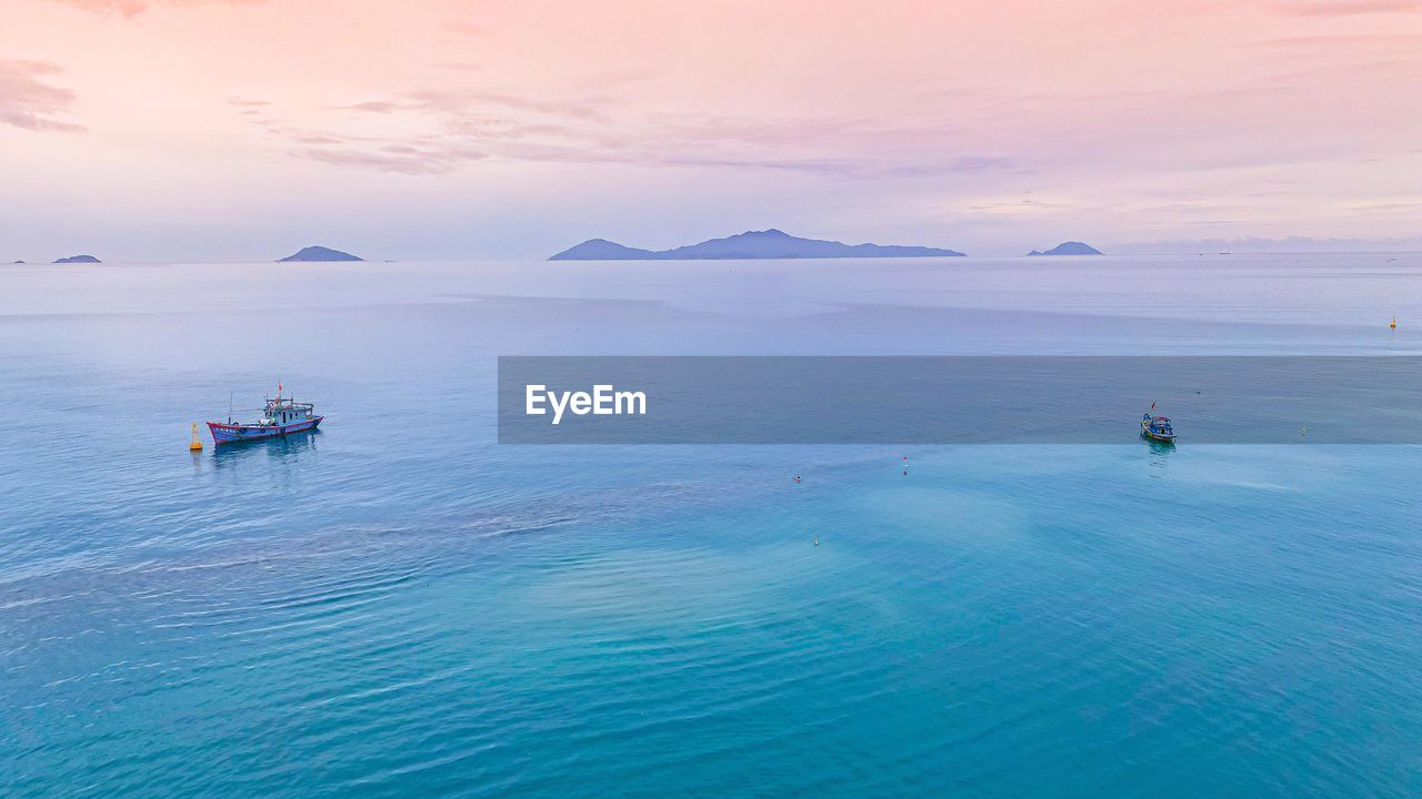 water, sea, beauty in nature, nautical vessel, transportation, scenics - nature, sky, travel, nature, land, travel destinations, mode of transportation, landscape, ocean, tranquility, blue, environment, horizon, sunset, holiday, tourism, vacation, tranquil scene, trip, outdoors, seascape, beach, cloud, idyllic, day, shore, sunlight, mountain, bay, sun, coast, horizon over water, relaxation, wave, non-urban scene, leisure activity, island, summer, vehicle, no people, wind wave, journey