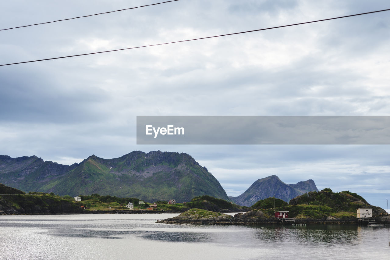 Scenic view of river and mountains against cloudy sky