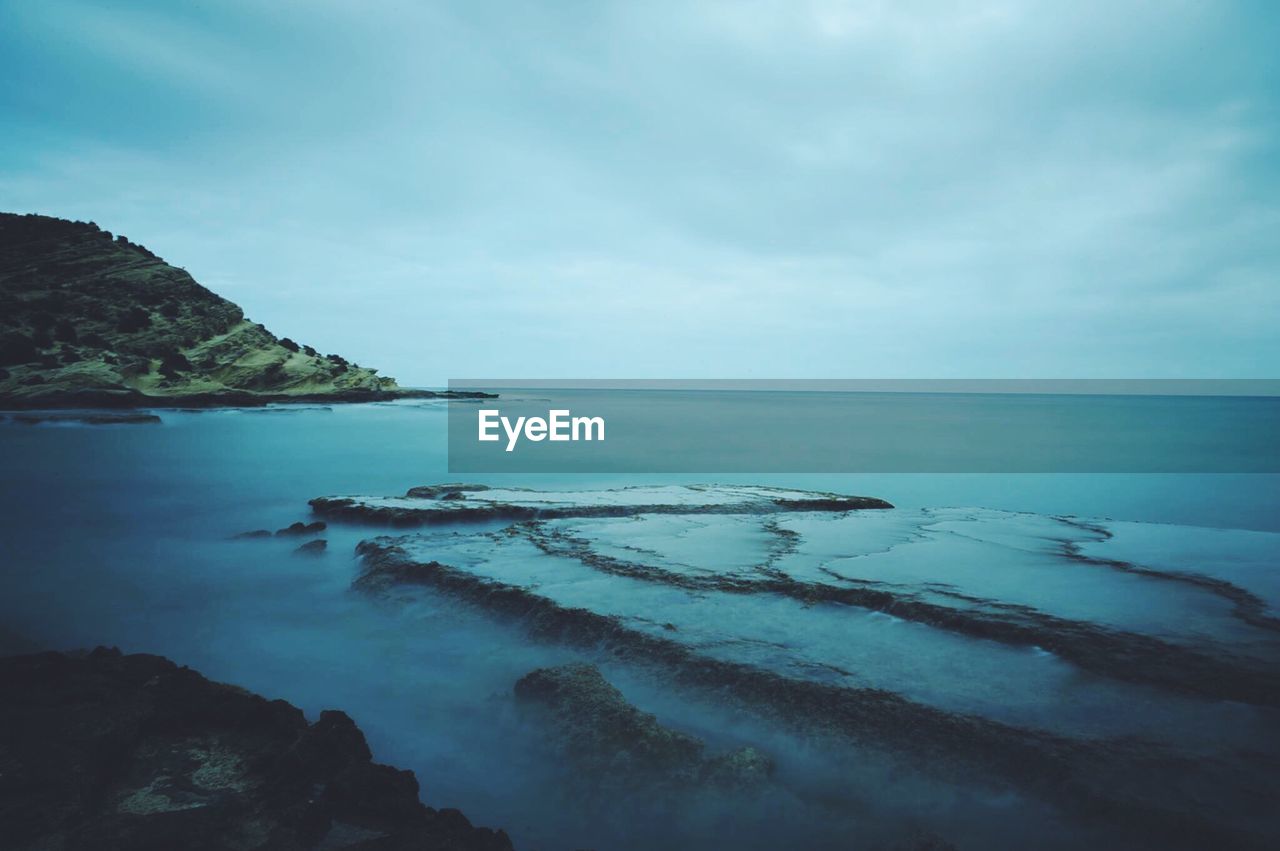 Scenic view of sea against cloudy sky