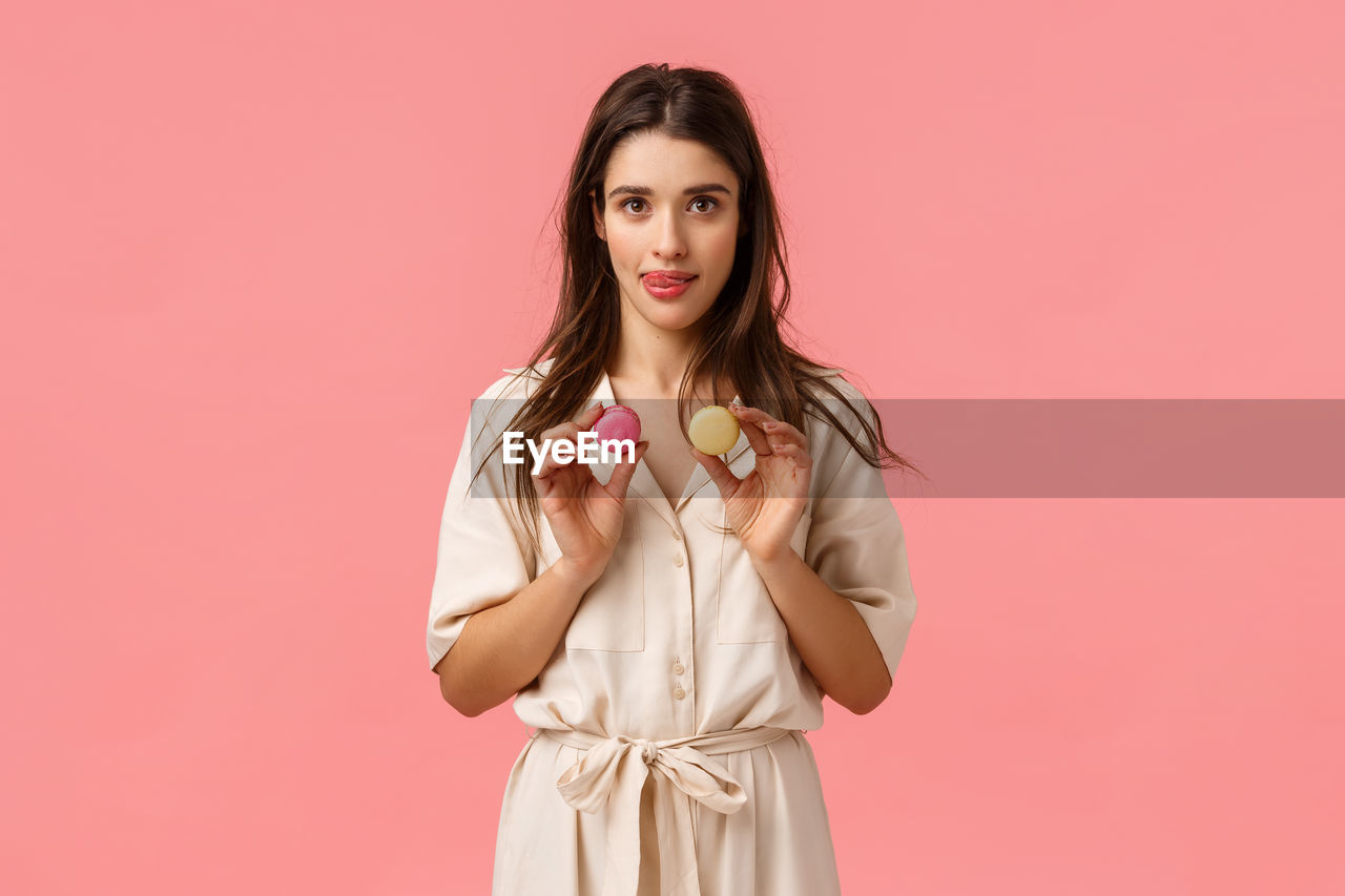 PORTRAIT OF A YOUNG WOMAN AGAINST RED BACKGROUND