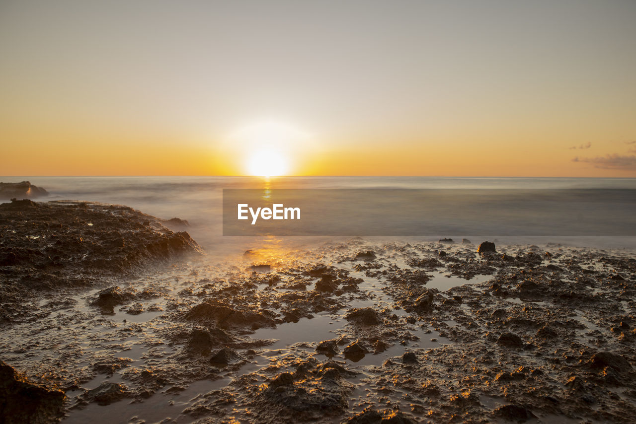 SCENIC VIEW OF BEACH DURING SUNSET