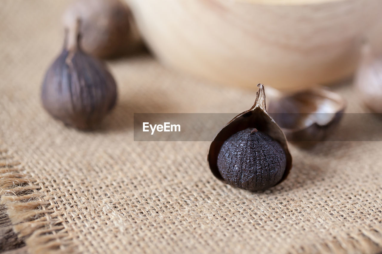 Black garlic on sack cloth and wooden table