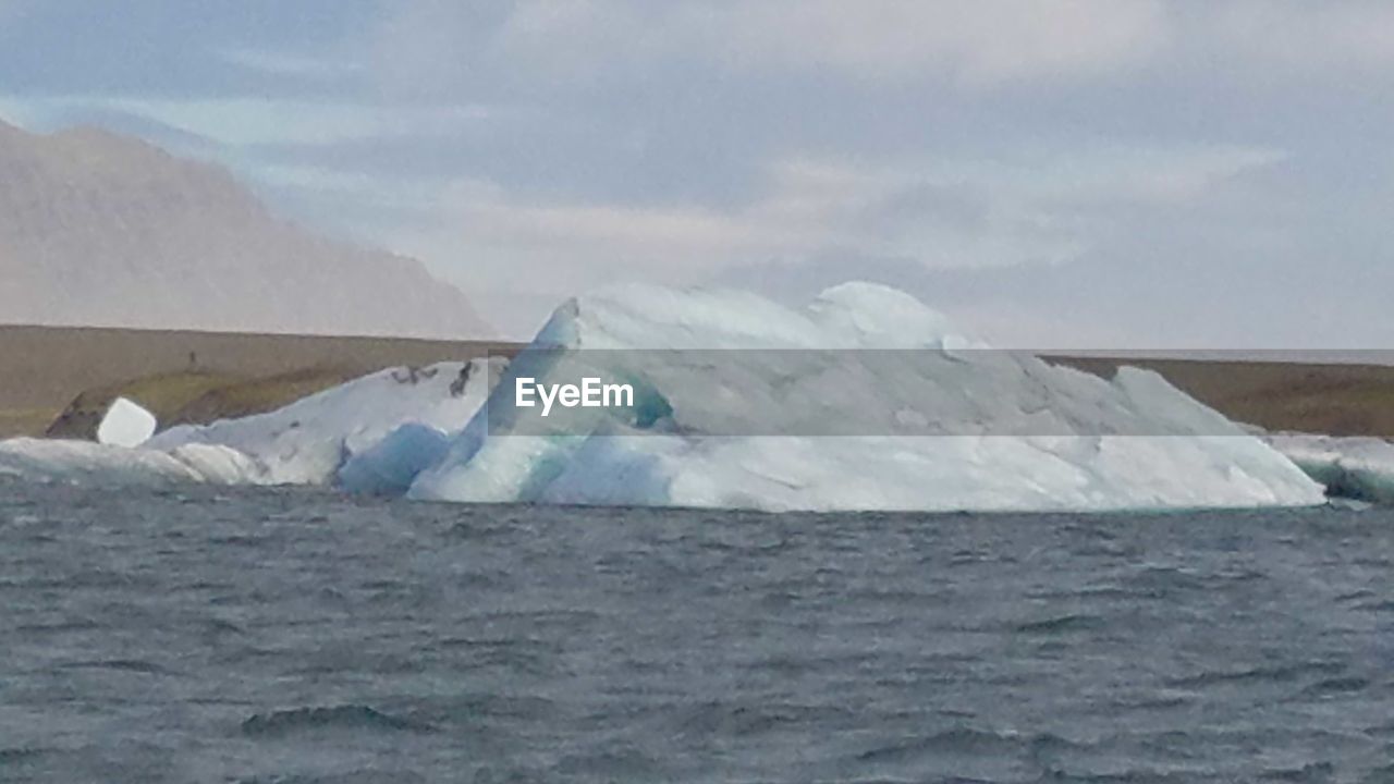 SCENIC VIEW OF SEA AGAINST MOUNTAINS