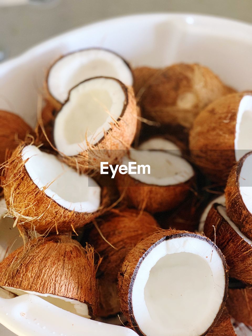 A white basket of fresh, cleaned coconuts