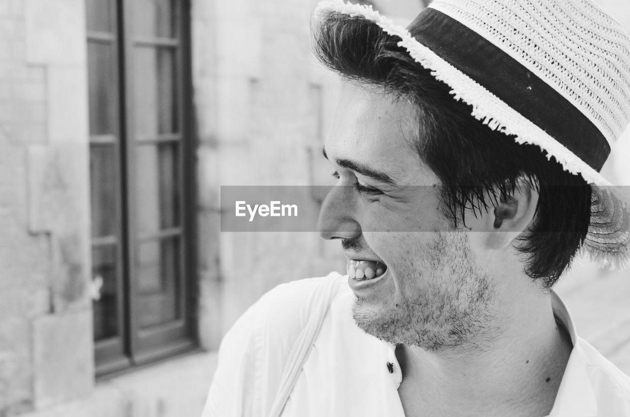 Close-up of smiling young man looking away