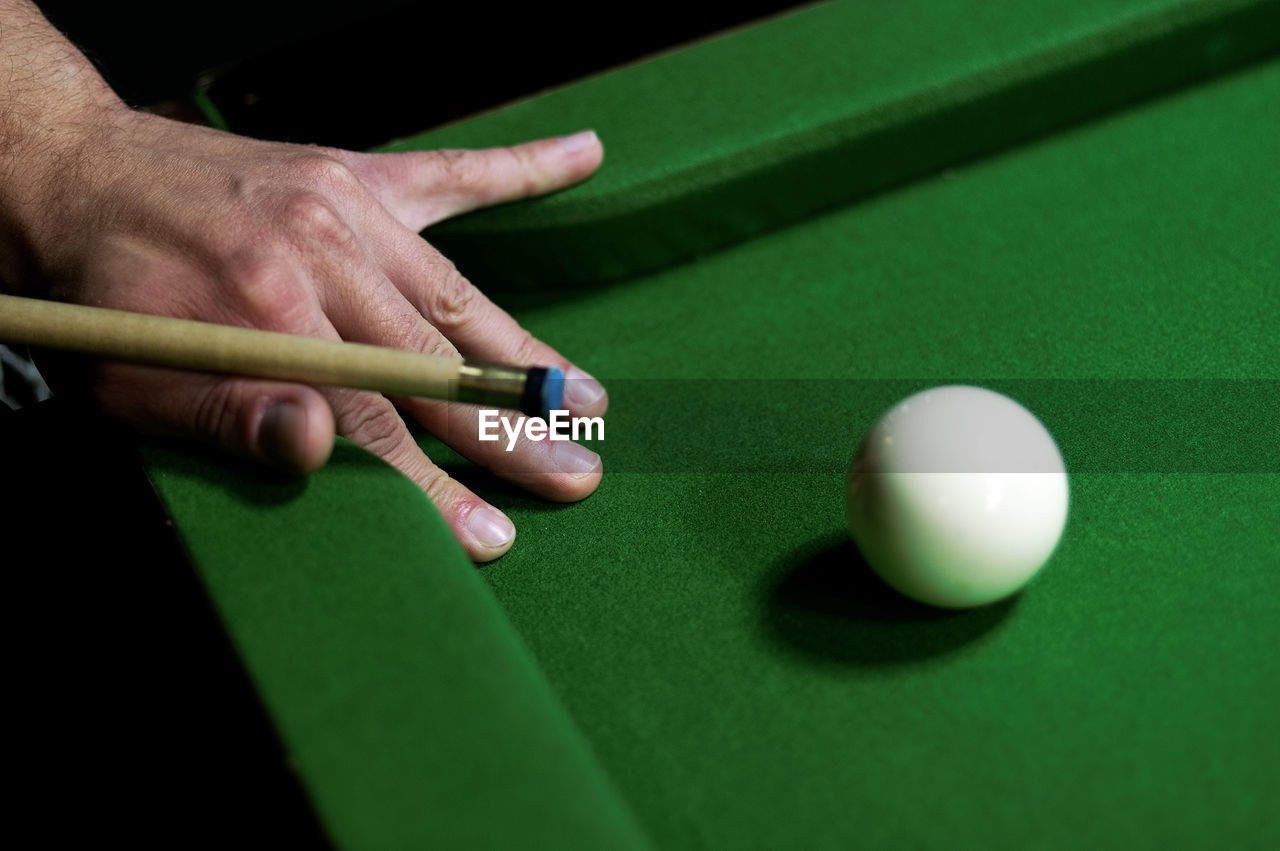 Cropped image of man playing pool at table