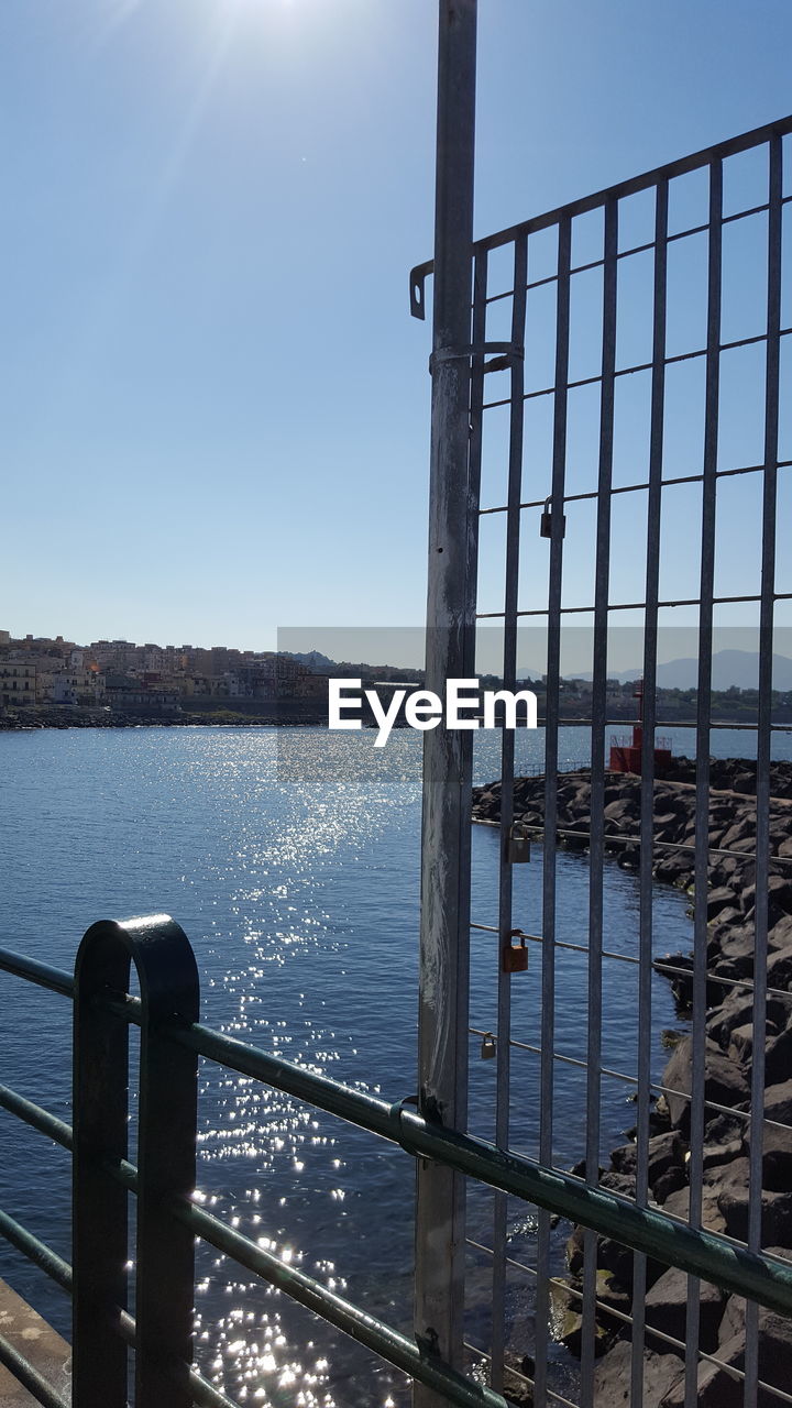 METAL RAILING BY SEA AGAINST SKY