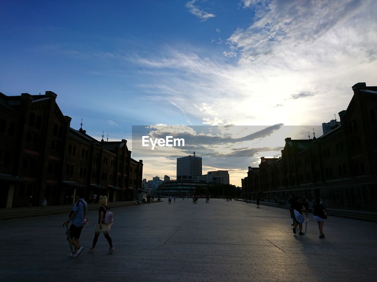 PEOPLE IN TOWN SQUARE AGAINST SKY