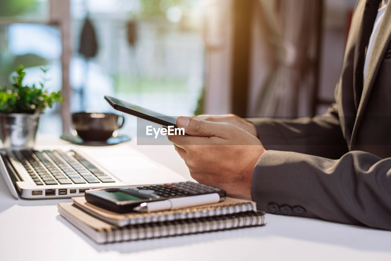 MAN USING LAPTOP ON TABLE