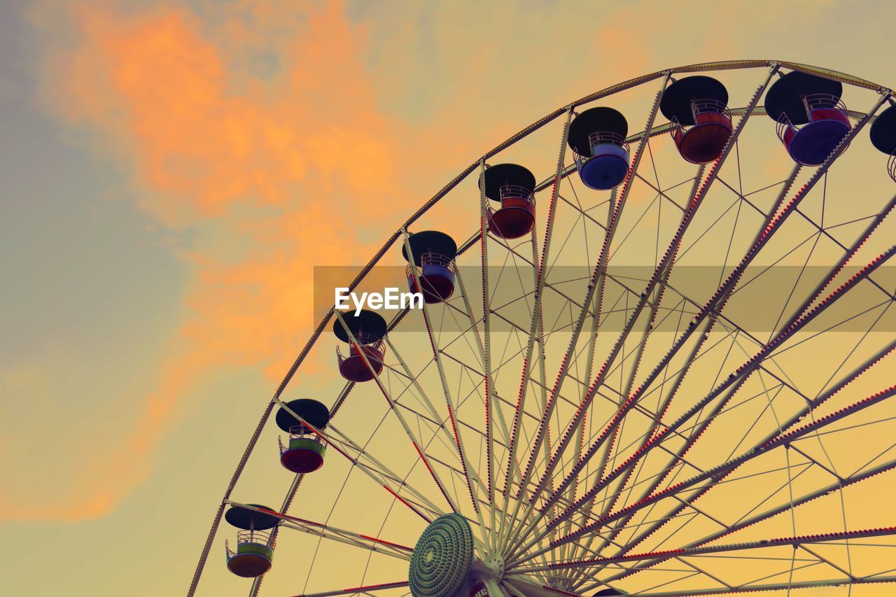 LOW ANGLE VIEW OF FERRIS WHEEL AGAINST ORANGE SKY