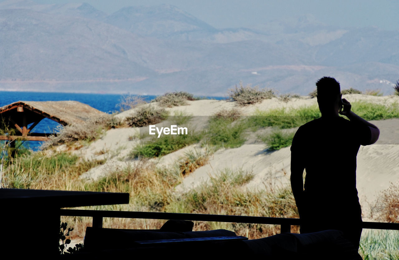 Silhouette man standing against mountains