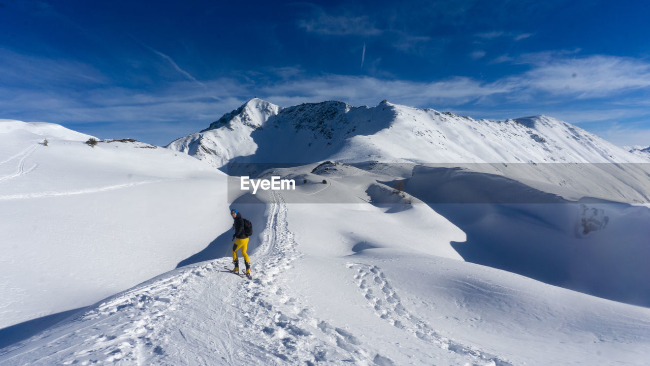 MAN SKIING ON SNOWCAPPED MOUNTAIN