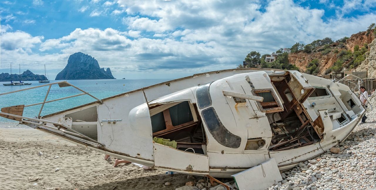 Tourist on beach near broken ship