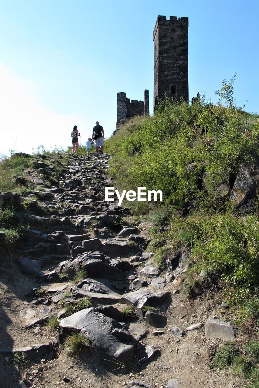 PEOPLE WALKING ON STONE WALL