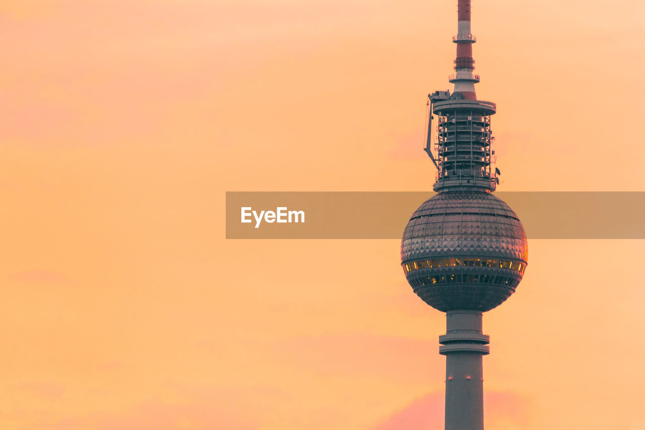 Low angle view of fernsehturm against sky during sunset