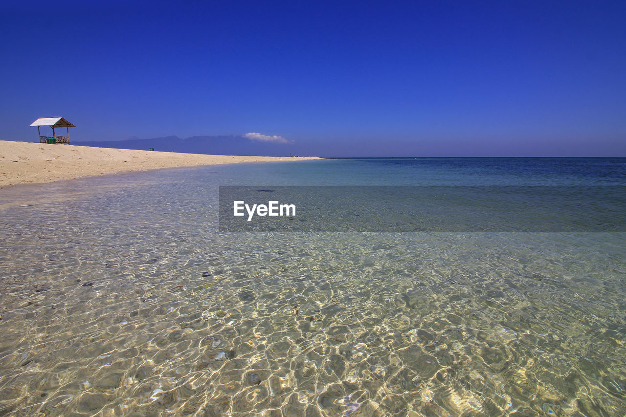 SCENIC VIEW OF BEACH AGAINST BLUE SKY