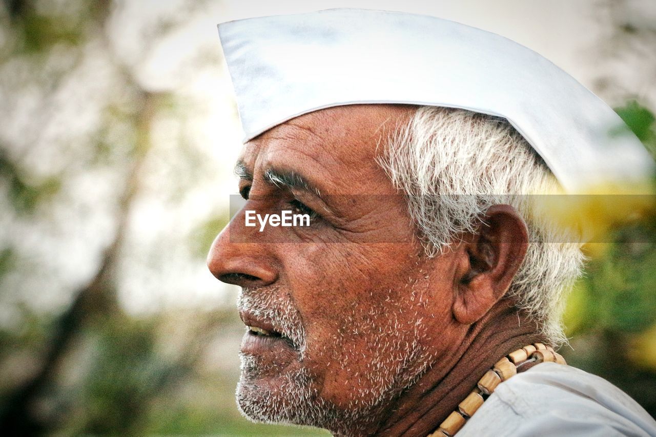 Side view of thoughtful senior man wearing white cap