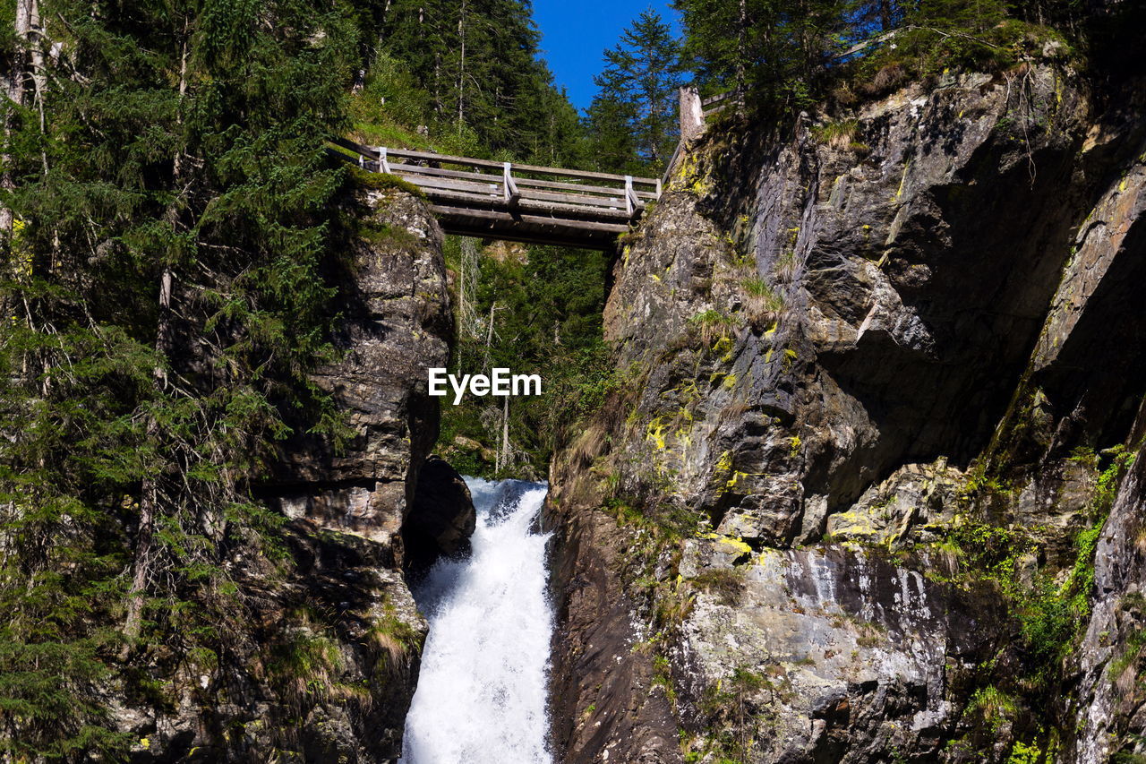 scenic view of waterfall against mountain