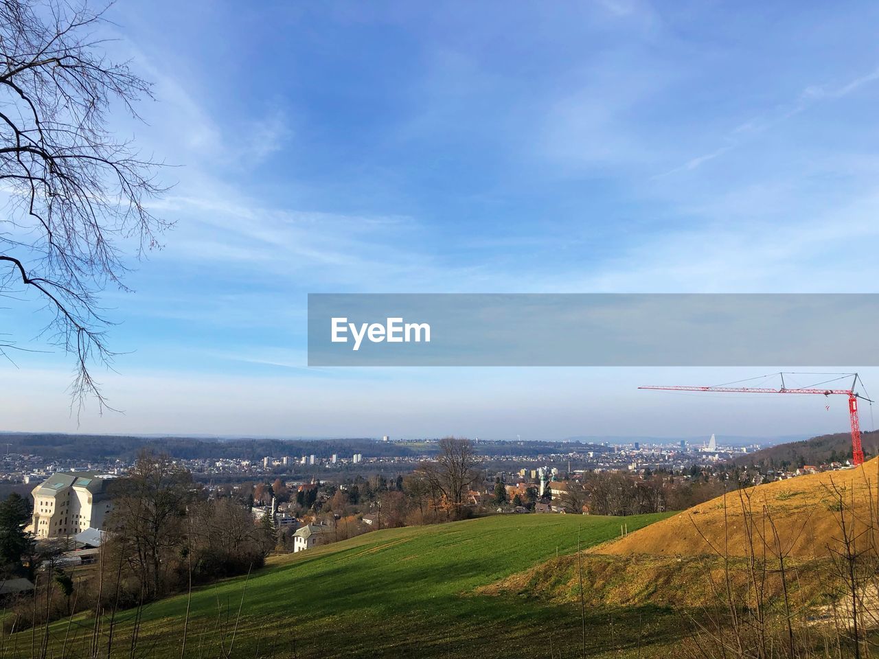 Scenic view of field by buildings against sky