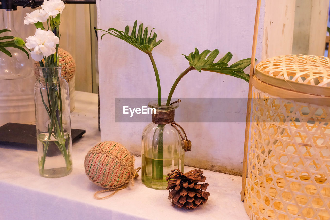 Close-up of vase on table against wall at home