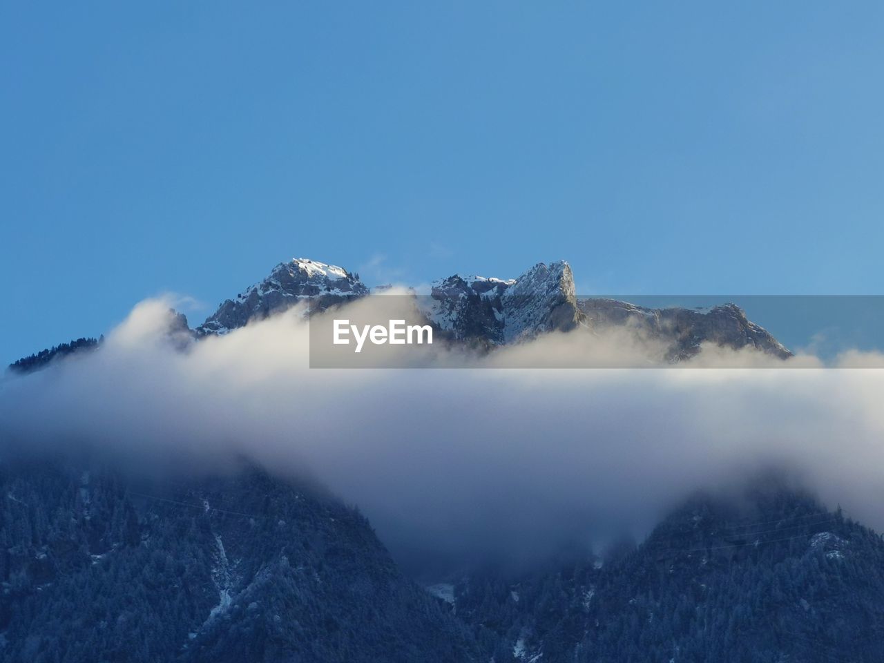 Scenic view of snowcapped mountains against clear blue sky