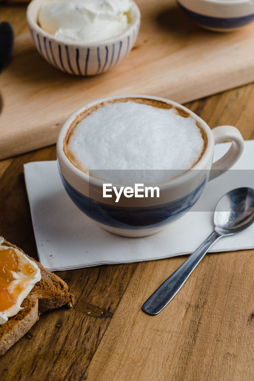 COFFEE CUP ON TABLE AGAINST WALL